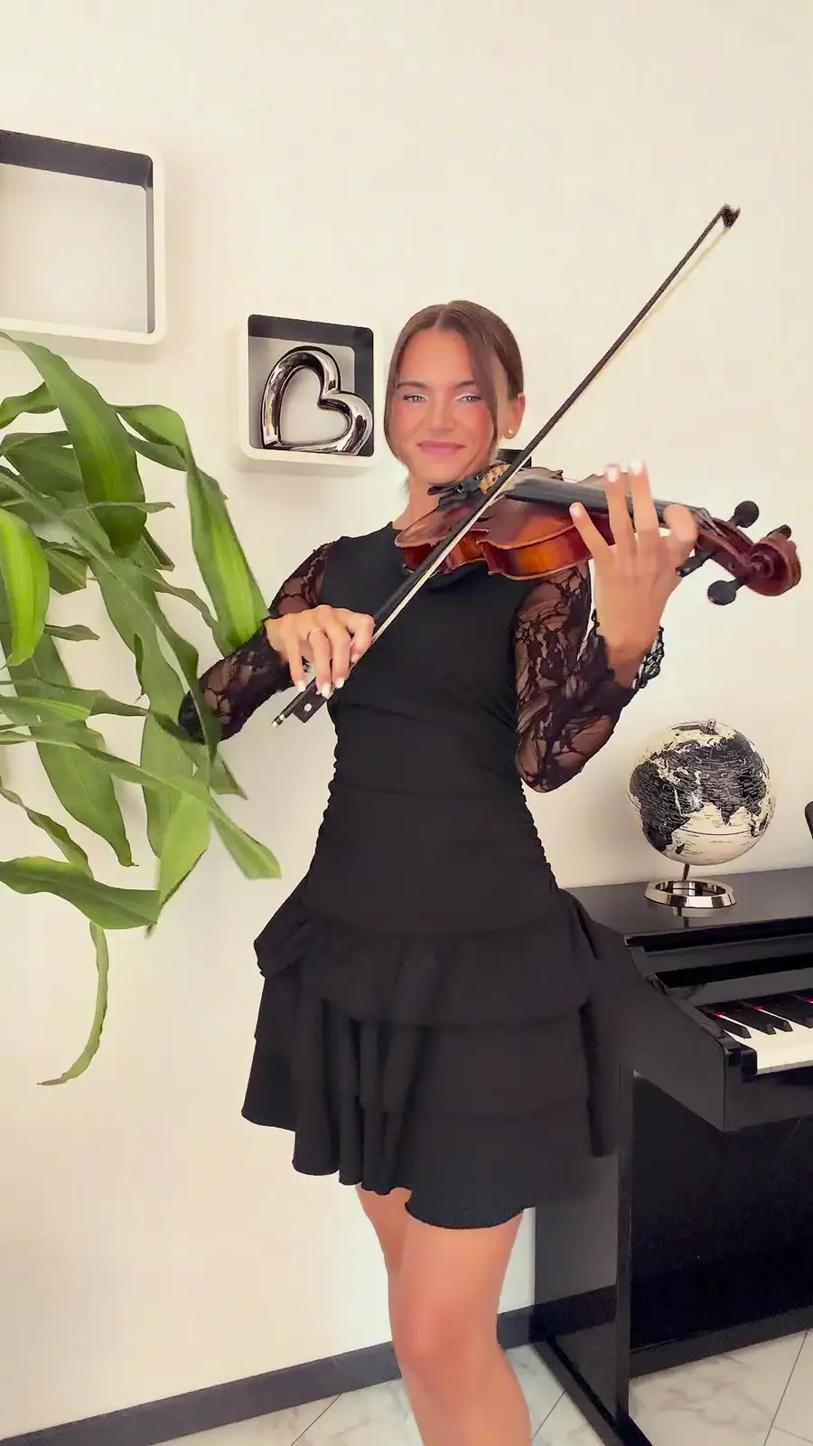 Geigerin Galina Friesen im schwarzen Spitzenkleid beim Spiel an einem Klavier