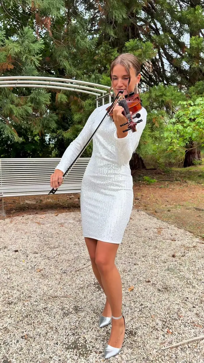 Violinistin Galina Friesen spielt im weißen Kleid unter alten Bäumen — Live-Musik für Trauungen im Freien